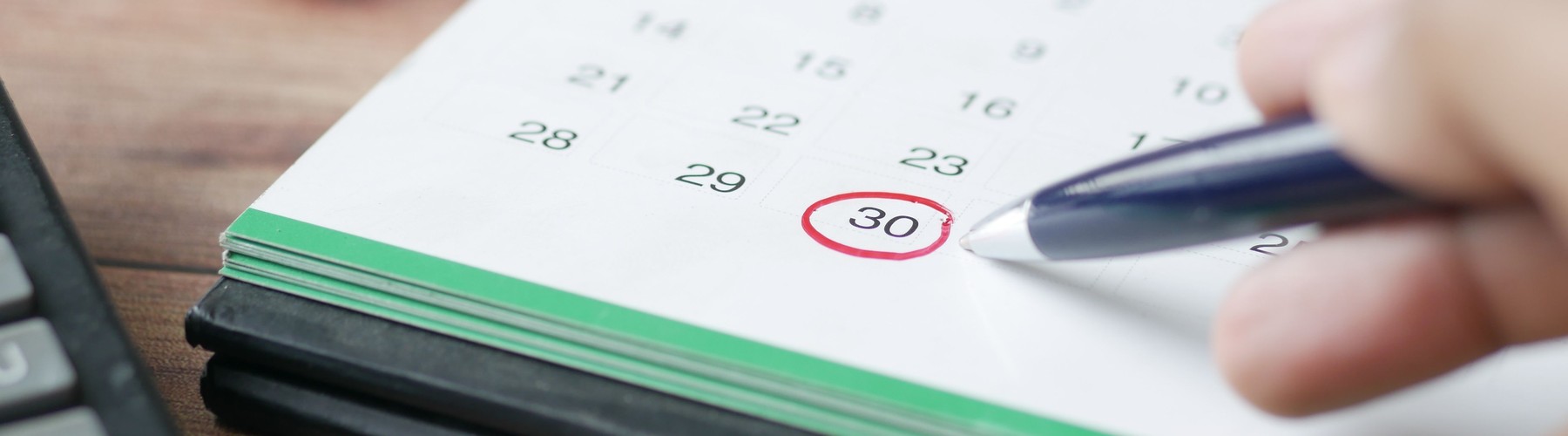 A calendar with a payment due date circled in red, next to a calculator